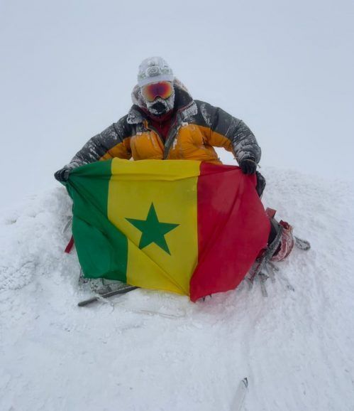 Dr Zakaria Naji Lamrani brandissant le drapeau du Sénégal au sommet du Mont Elbrouz